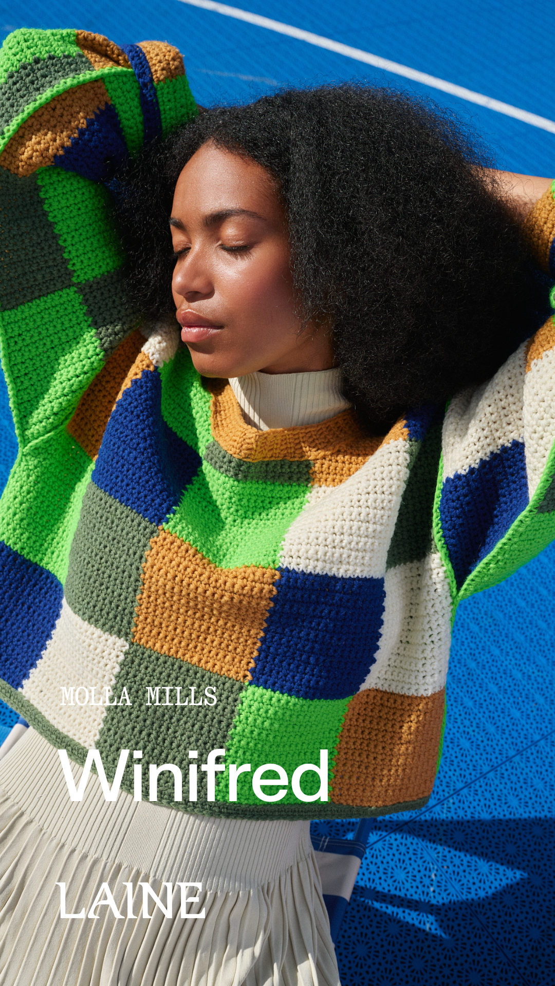 Woman wearing a colorful crochet Winifred sweater designed by Molla Mills on a blue background