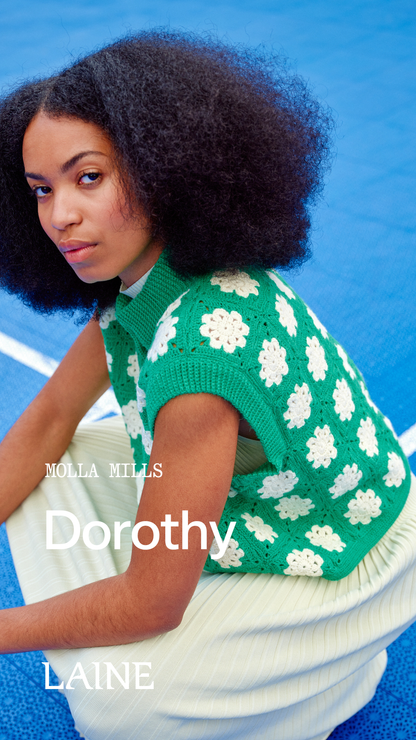 Woman wearing a green floral sleeveless Dorothy top designed by Molla Mills against a blue background